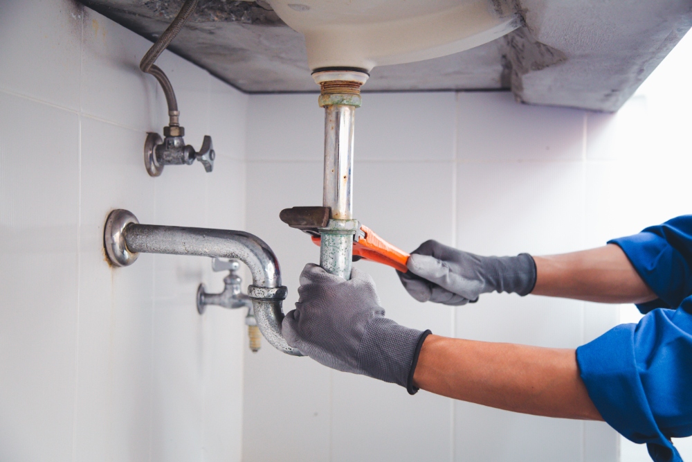 Plumber repairing sink pipe