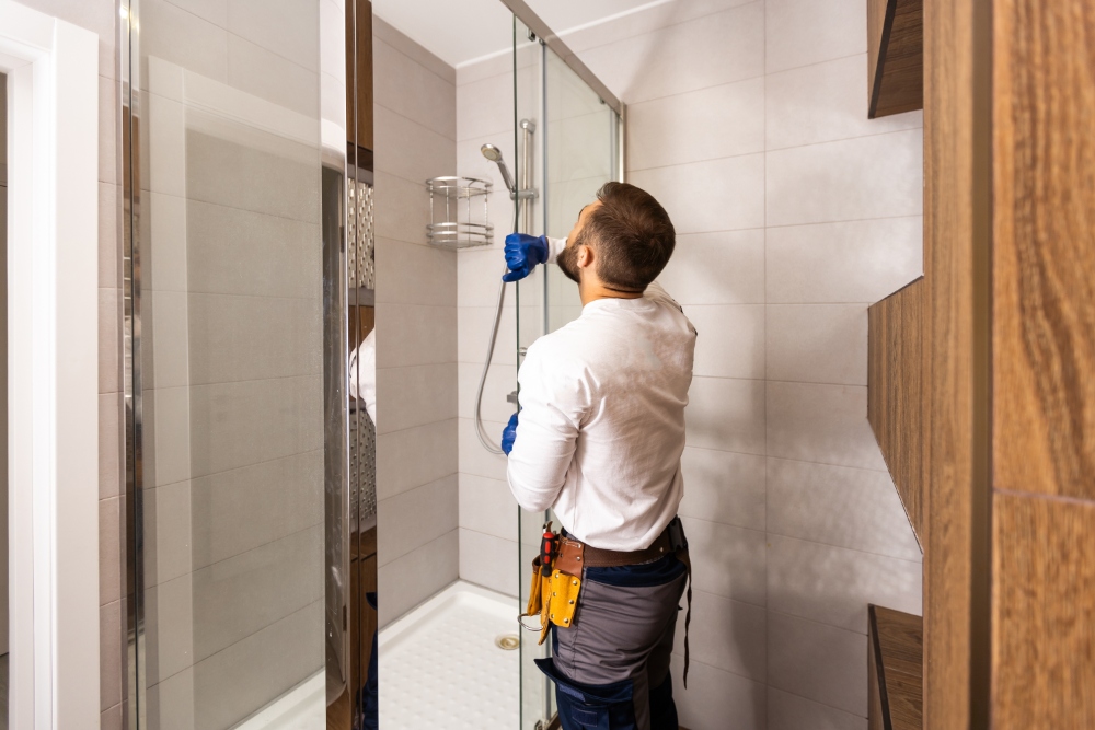 Man cleaning showerhead in bathroom